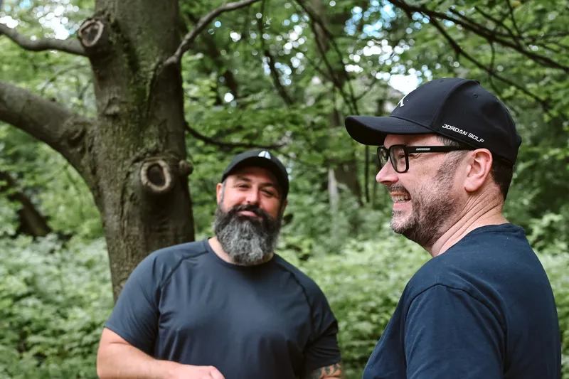 Two Purkinje colleagues talking while walking through a park